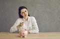 Woman waves a punishing finger at the piggy bank as a sign that she will now be more frugal. Royalty Free Stock Photo