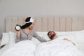 Emotional woman waking up man in bedroom. Being late concept Royalty Free Stock Photo