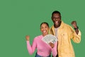 Emotional young african american couple with money cash clenching fists Royalty Free Stock Photo