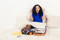 Emotional young brunete woman preparing for travelling, is packing her suitcase. Royalty Free Stock Photo