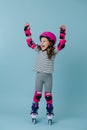 Emotional young girl raised her hands of glee while standing on roller skates