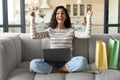 Emotional young lady with laptop and shopping bags buying things online on sale, purchasing goods on web from home Royalty Free Stock Photo