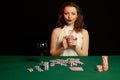 Emotional young lady in a white blouse drinking wine from a glass and playing cards Royalty Free Stock Photo