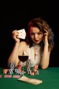 Emotional young lady in a white blouse drinking wine from a glass and playing cards Royalty Free Stock Photo