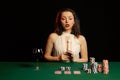 Emotional young lady in a white blouse drinking wine from a glass and playing cards Royalty Free Stock Photo