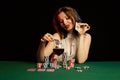 Emotional young lady in a white blouse drinking wine from a glass and playing cards Royalty Free Stock Photo