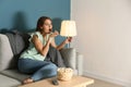 Emotional young woman eating popcorn while watching TV at home Royalty Free Stock Photo