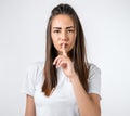 Emotional young woman keeping index finger at her lips, saying Shh, Keep silent, It`s secret