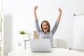 Emotional young woman with laptop celebrating victory