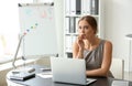 Emotional young woman after making mistake during work with laptop in office Royalty Free Stock Photo