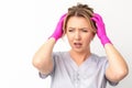 The emotionally shocked young female medical worker holding hands on her head fell into panic on white background Royalty Free Stock Photo