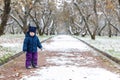 Emotions in the child`s view, confusion and sadness in the eyes of the child. Late autumn and the first snow in the park