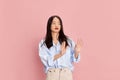 Emotions of disapproval. Portrait of young beautiful girl in casual clothes posing against pink studio background