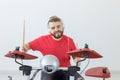 Emotions, electronic drums and people concept - young man drummer playing the drum Royalty Free Stock Photo