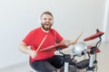 Emotions, electronic drums and people concept - young man drummer playing the drum Royalty Free Stock Photo