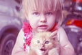 Emotions, little girl with a little red kitten Royalty Free Stock Photo