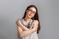 Emotions and people. Young brunette woman in glasses and blouse, hugging herself by the shoulders. Emotion of calm Royalty Free Stock Photo