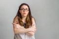 Emotions and people. Young brunette woman in glasses and blouse, hugging herself by the shoulders. Emotion of uncertainty Royalty Free Stock Photo