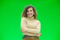 Portrait of funny kinky girl sticking out her tongue at camera against green background. Royalty Free Stock Photo