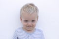 Emotions. Shy toddler against wall. Close-up portrait of cute little boy Royalty Free Stock Photo