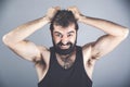 Emotions, stress, madness and people concept - crazy shouting man rending ones hair in t-shirt over gray background Royalty Free Stock Photo