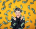 Emotive girl smiles broadly, spreads hands or applause overjoyed, exclaims happiness as  money are falling like dollar rain from Royalty Free Stock Photo