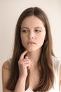 Emotive headshot portrait of doubtful young woman