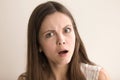 Emotive headshot portrait of shocked young woman