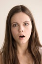 Emotive headshot portrait of stunned young woman