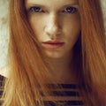 Emotive portrait of a fashionable model with red ginger hair and natural make-up. Perfect skin with freckles. Close up. Daylight