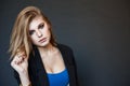 Emotive portrait of a young beautiful girl with curly long hair posing over black background. Perfect skin and hair. Spa salon. Cl Royalty Free Stock Photo