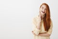 Emotive redhead girl grinning from happiness. Portrait of charming young european female with ginger hair feeling