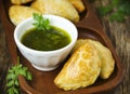 Empanadas with chimichurri sauce.