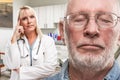 Empathetic Doctor Standing Behind Troubled Senior Adult Man In Office Royalty Free Stock Photo