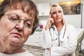 Empathetic Doctor Standing Behind Troubled Senior Adult Woman In Office