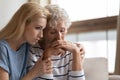 Empathic daughter embracing desperate middle aged mother. Royalty Free Stock Photo