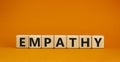 Empathy symbol. The concept word Empathy on wooden cubes. Beautiful orange table, orange background, copy space. Business,