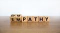 From empathy to sympathy. Turned cubes and changed the word `empathy` to `sympathy`. Beautiful wooden table, white background.