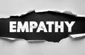 Empathy word shown under torn paper. Emotional intelligence theme expressing compassion, understanding, kindness, and connection Royalty Free Stock Photo