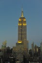 Empire State Building and skyline at dusk with lights on