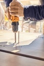 Employee assembles dining table with electric screwdriver outdoors