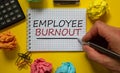 Employee burnout symbol. Mail hand writing `Employee burnout` on white note, beautiful yellow background, paper clips, metalic p