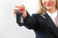 Employee of a car sales company hand over car key to client Royalty Free Stock Photo