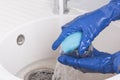 An employee of the cleaning service of residential premises washes a glass glass in water