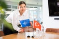 Employee of delegation prepares negotiating table - sets up flag of NATO & x28;OTAN& x29; and Turkey