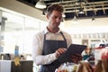 Employee In Delicatessen Checking Stock With Digital Tablet