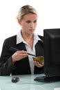 Employee eating at her computer Royalty Free Stock Photo
