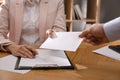 Employee giving resignation letter to boss in office