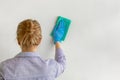Employee hand in blue rubber protective glove wiping wall from dust with dry rag. Commercial cleaning company