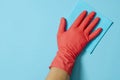 Employee hand in rubber protective glove with micro fiber cloth wiping wall from dust. Commercial cleaning company concept